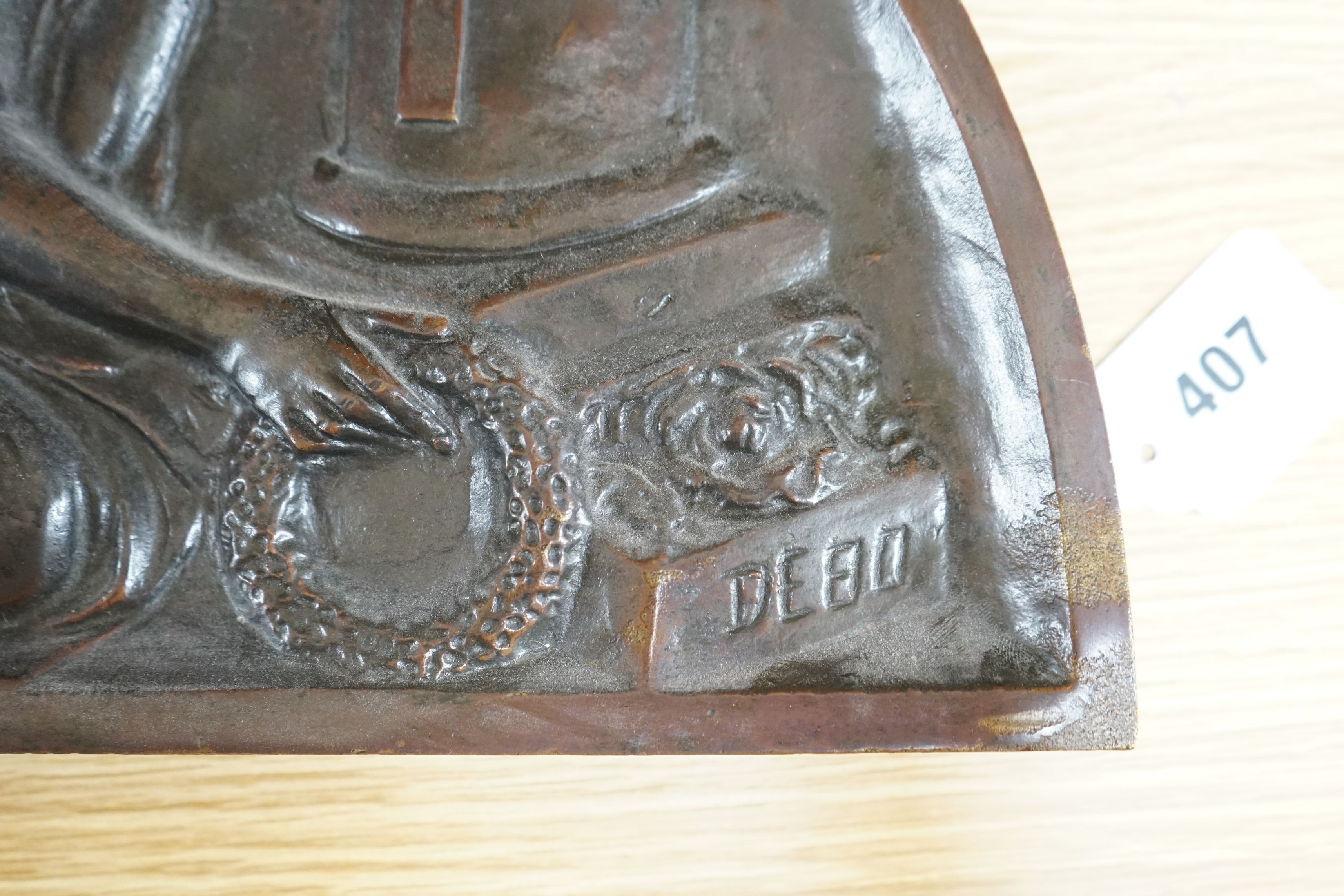 A demi-lune cast bronze panel depicting a weeping angel, signed DEBO, 49.5 x 26.5cm